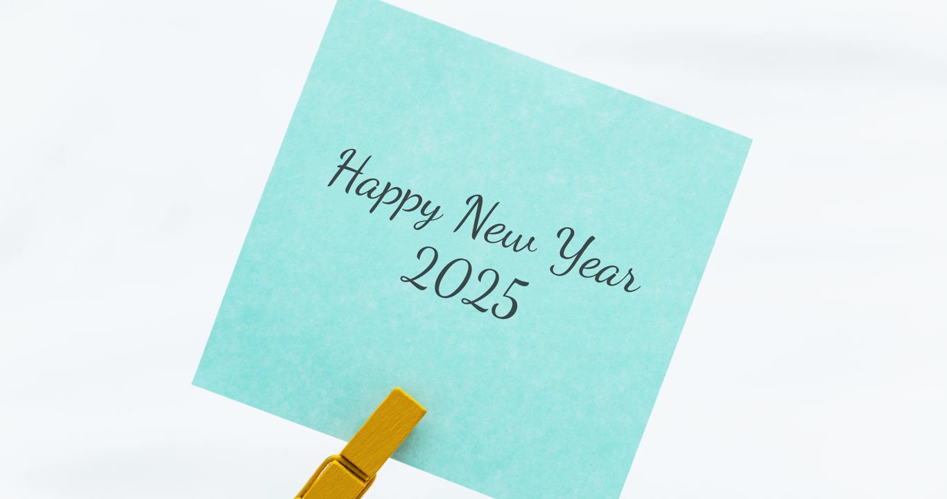 A vibrant blue note wishing a Happy New Year 2025 reflects hope and new beginnings in a minimalist home setting.