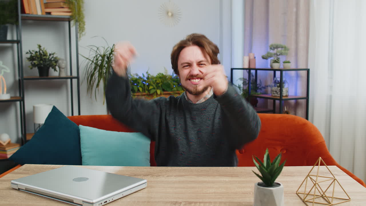 мужчина празднует успех дома.