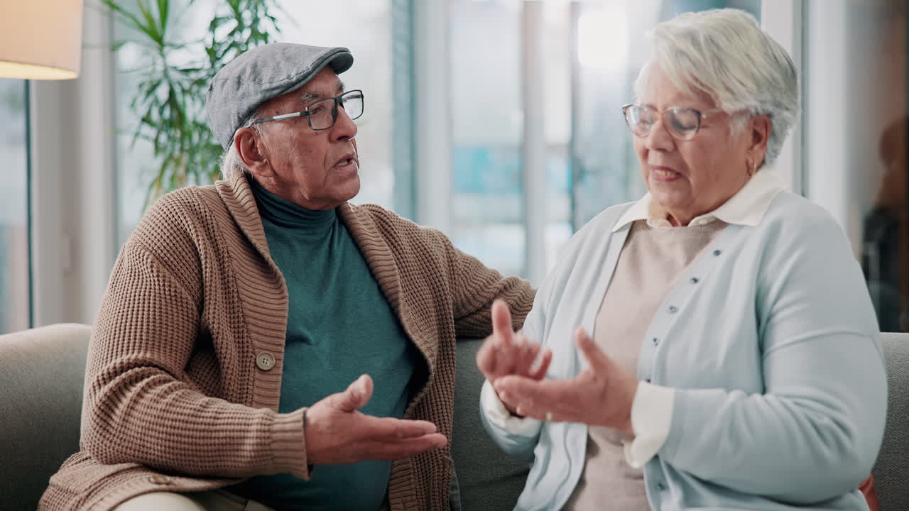 Una pareja mayor conversando en casa