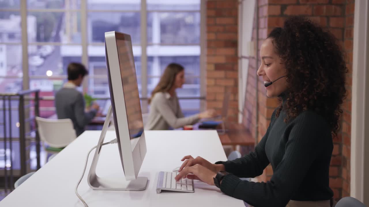 Kreative Geschäftsfrau mit Headset telefoniert im modernen Büro.