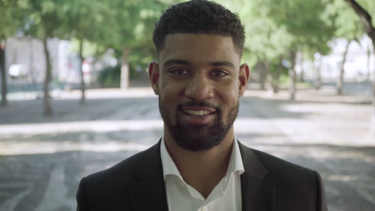 un hombre afroamericano alegre mirando a la cámara.