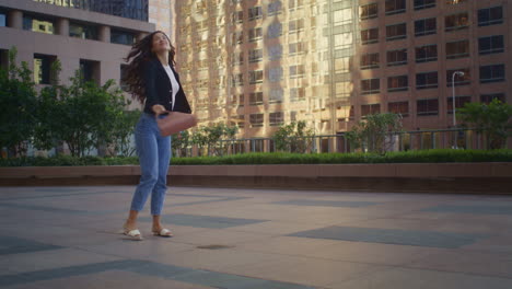 una mujer despreocupada girando en la calle de la ciudad. una chica asiática alegre caminando por la metrópolis.