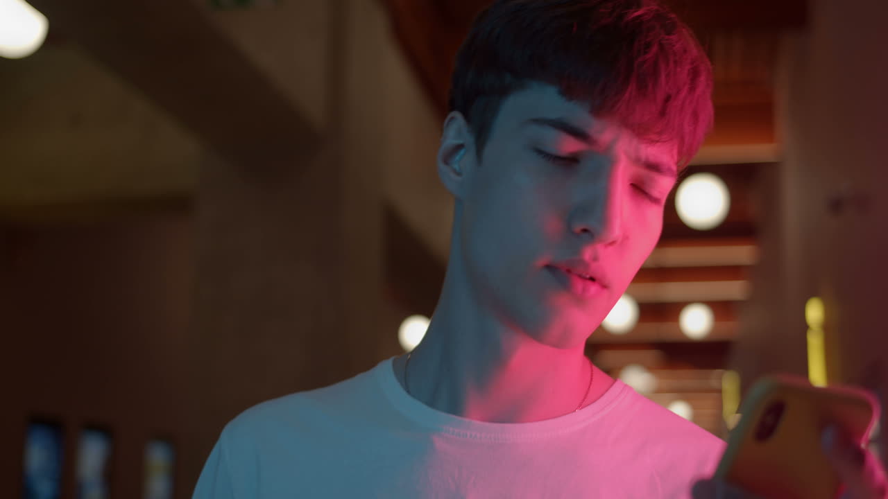 실내에서 스마트폰을 사용하는 젊은 남자