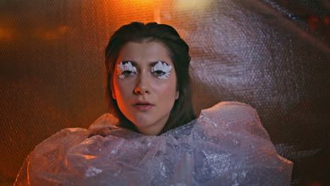 unique style woman looking thoughtfully in bubble wrap revealing petal eyelashes