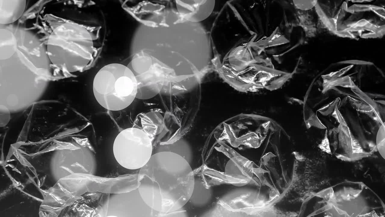 회색과 색의 보케 빛 점이 투명한 시트, 필름 및 거품 포장 위에 움직이는 애니메이션