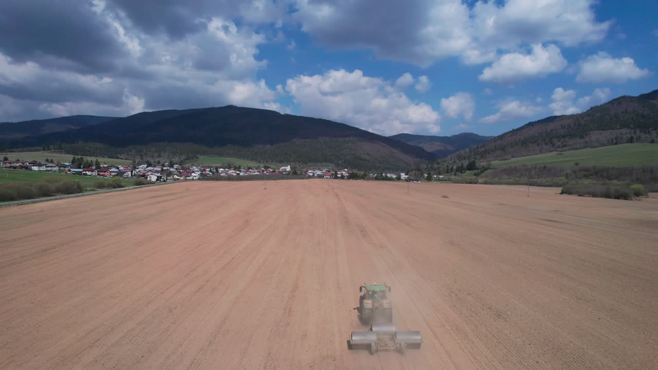 siguiente toma aérea de un agricultor cortando su campo con un tractor a tiempo para la nueva temporada