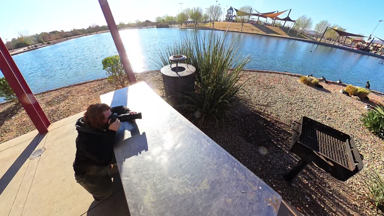 Red haired male photographing Mandarin Duck at Mansel Crater Park in Queen Creek Arizona.