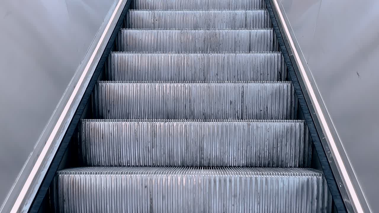 Metal escalator steps in motion inside a modern public space