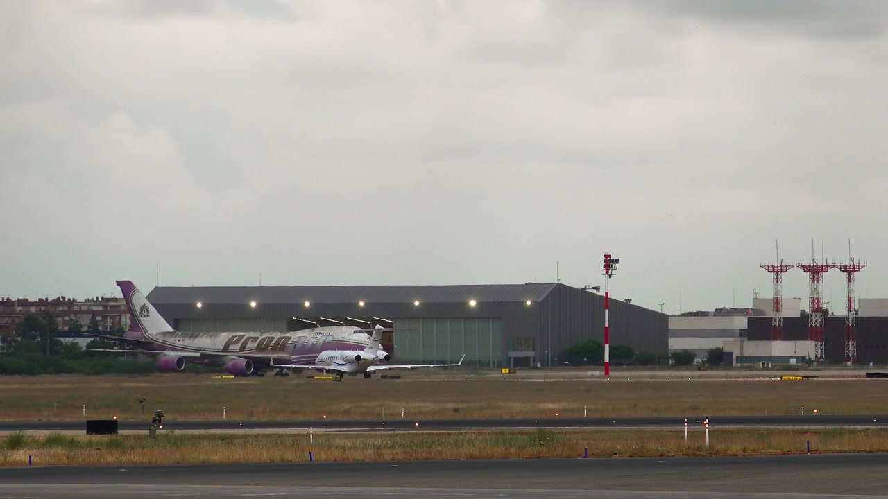 Privatfly taxier forbi et stort fragtfly i en lufthavn