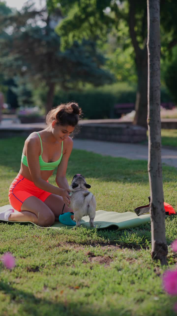 mujer haciendo ejercicio con su pug en el parque