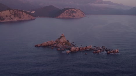 órbita alrededor de la iglesia de st nedelja en montenegro durante la puesta de sol mágica, aérea