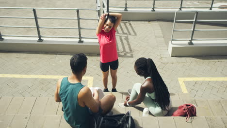 Three-active-people-taking-a-break-on-the-stairs