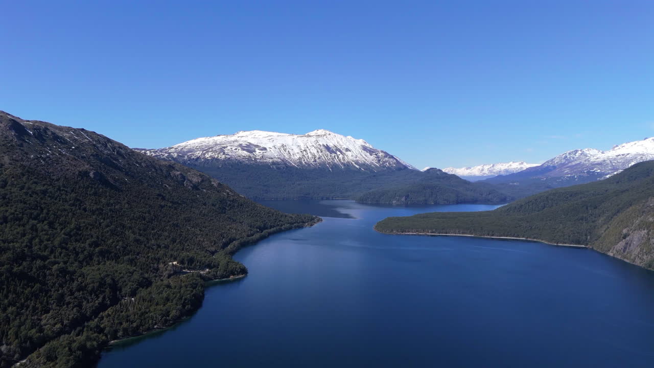 Aerial panoramic view of Futalaufquen Lake in the Los Alerces National Park. Snowy mountains on the horizon.