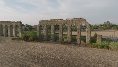 an aerial shot of an italian aqueduct as the drone approaches the structure.
