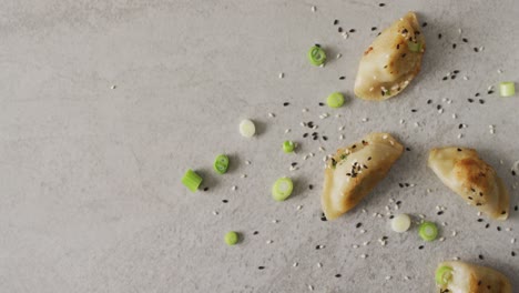 composición de albóndigas de gyoza y salsa de soja con palillos sobre fondo gris
