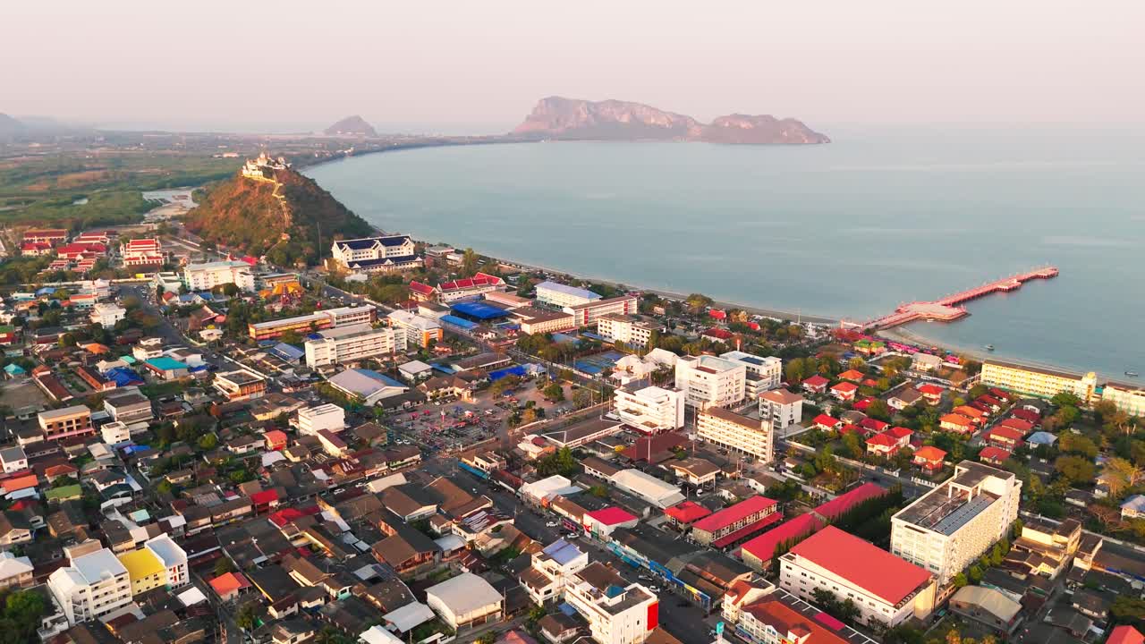 Capture the breathtaking aerial view of Prachuap Khiri Khan, where the vibrant city meets the beautiful ocean. This stunning scene highlights the perfect blend of urban life and natural beauty.