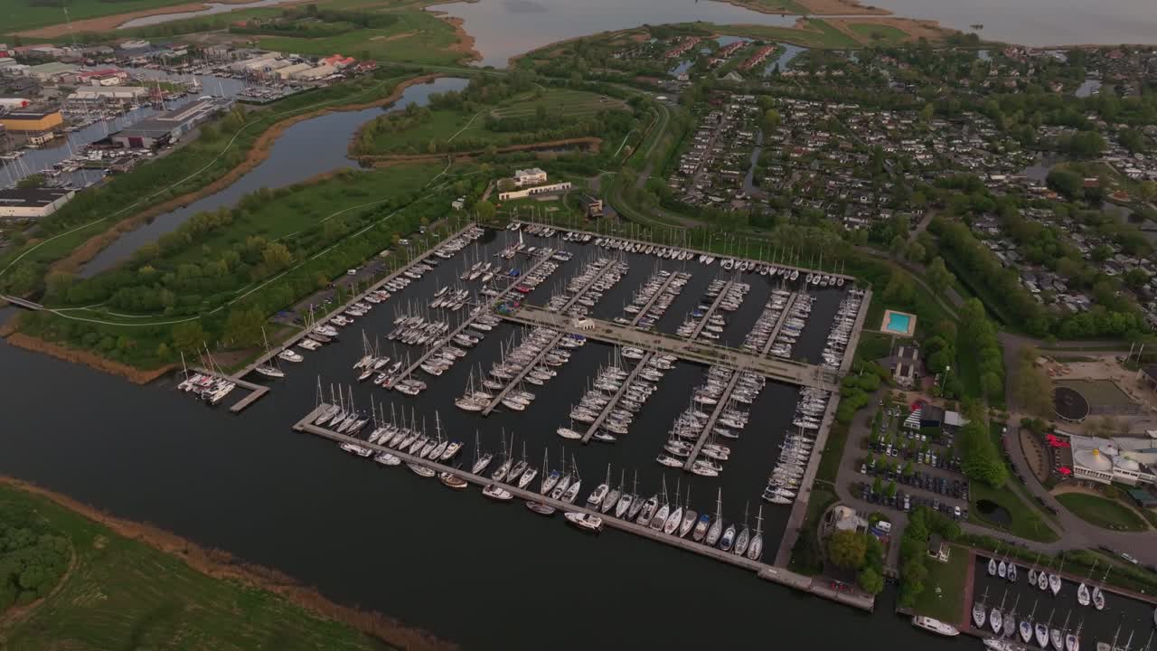 Sunset glows on Dutch marina with yachts from the sky