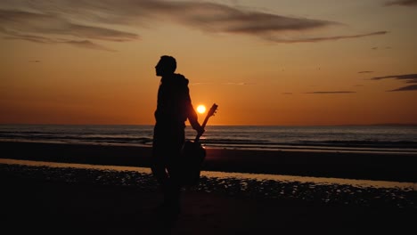 man running with guitar in back sand beach at sunset-36