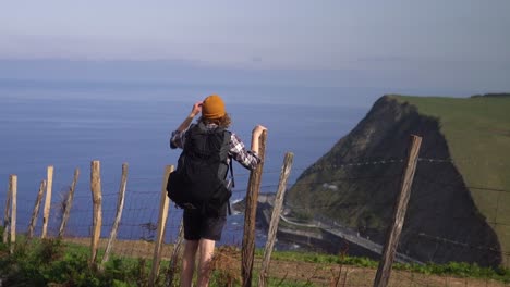 Mann,-Der-Mit-Dem-Rucksack-Wandert-Und-In-Die-Ferne-Zur-Klippe-Des-Ozeans-Blickt