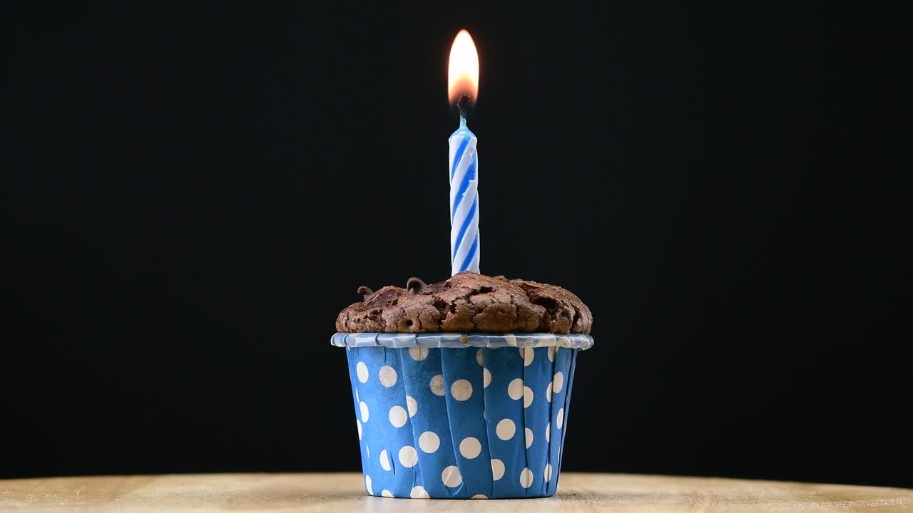 fiesta de pasteles con vela en fondo azul cinemagraph bucle sin costuras.