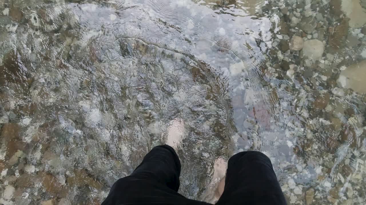 Person Walking Through a Shallow River
