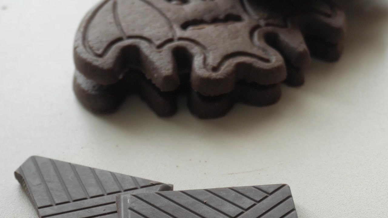 Biscoitos de morcego e pedaços de barras de chocolate - Doces de Halloween - leve movimento de câmera para cima.