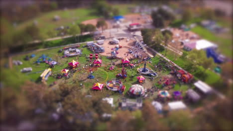 tilt shift effect makes the nostalgic county fair carnival event look like miniature toy setup - creative time lapse