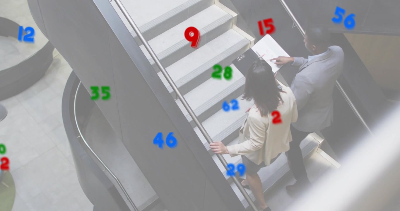 Colegas de negocios notando números y entrando a la escalera mientras revisan una tableta para análisis.