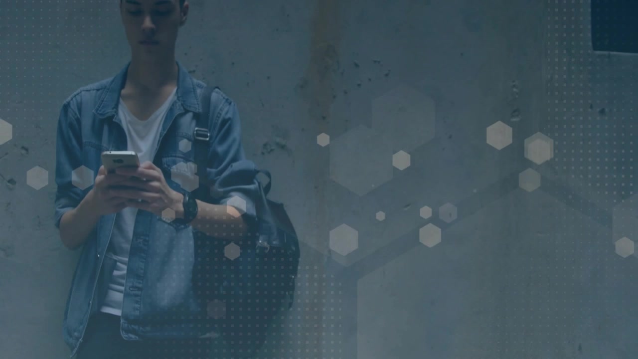 Male commuter tapping smartphone by concrete wall, hex bokeh dotted overlay showing technology data