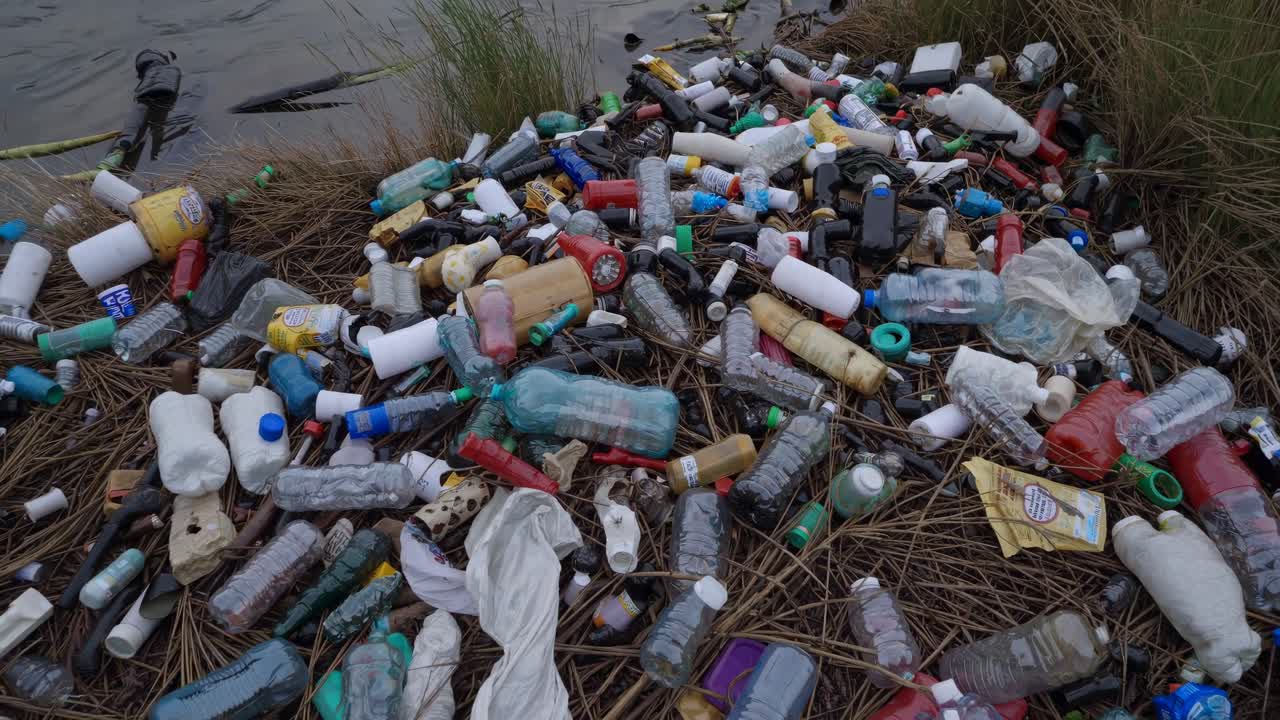 Massive Plastic Waste and Garbage Polluting a Riverbank