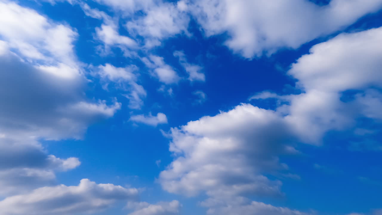 Beautiful white clouds floating by the azure sky. Low angle view on the clouds flying away. Timelapse.