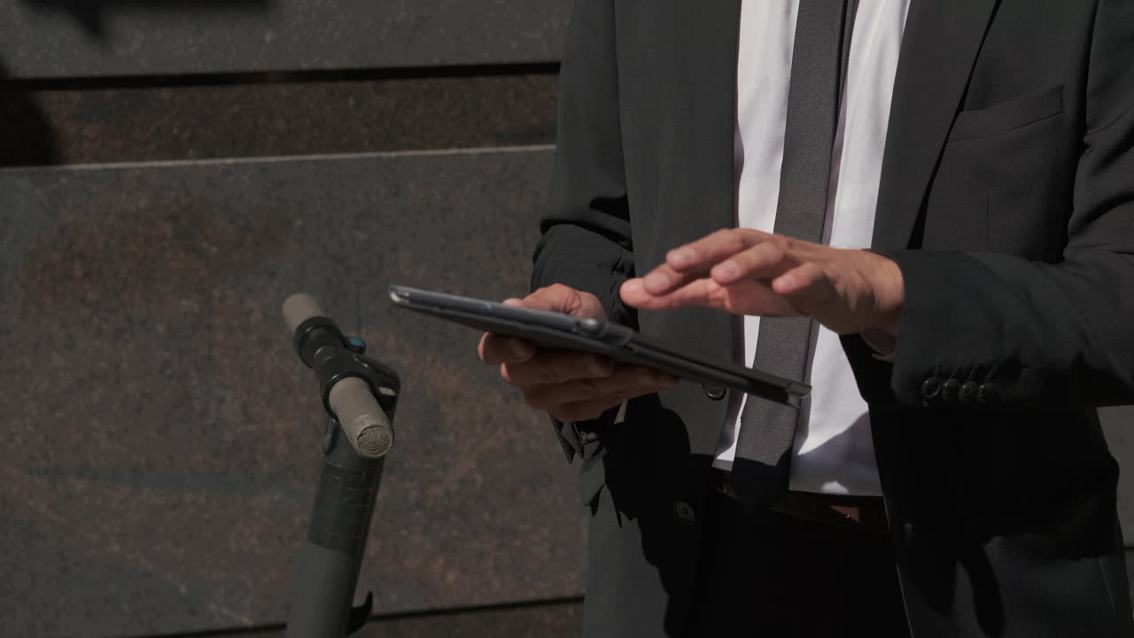 전기 스쿠터 근처에 태블릿을 사용하는 사업가