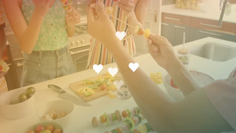 preparing vegetable skewers, people in kitchen with heart animation floating