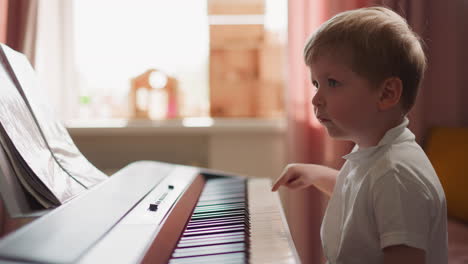 adorable niño cambia de modo y toca el piano eléctrico