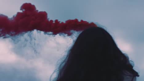 young-woman-playing-with-pink-smoke-grenade-dancing-on-seaside-beach-enjoying-freedom