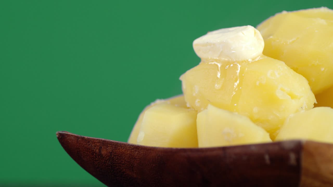 접시에 버터 한 조각을 넣은 뜨거운 긴 감자.