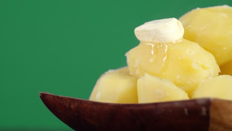 patatas cocidas calientes con una rebanada de mantequilla en el plato.