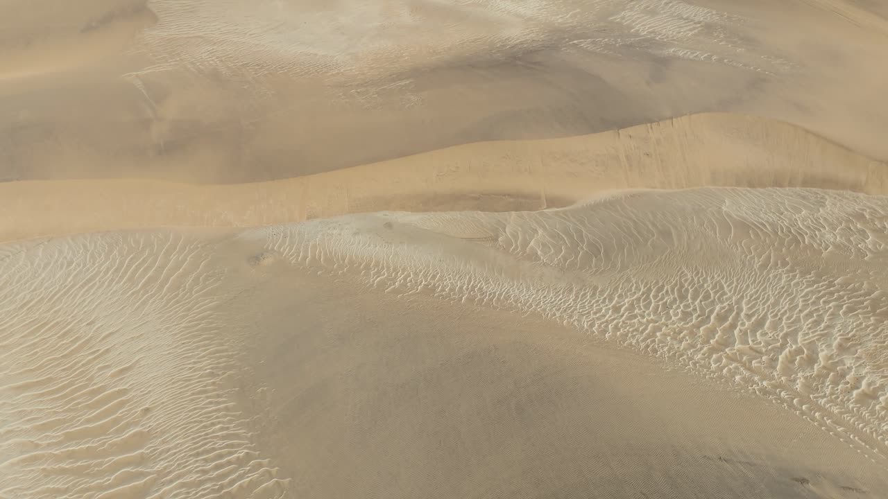 drone footage flying above Namib Desert dunes near Swakopmund, aerial top down desert sand patterns