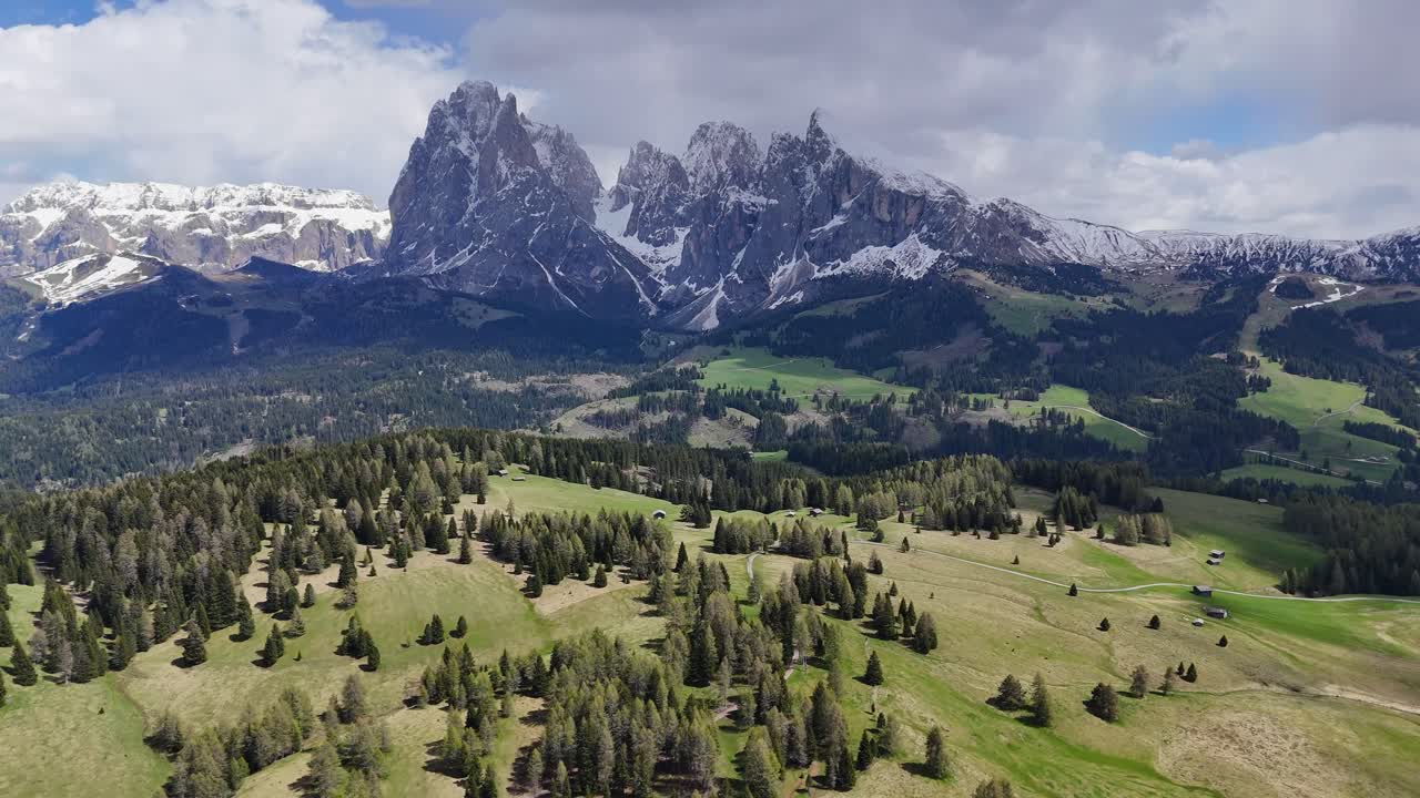 Alpe di Siusi and Sassolungo Group in the Dolomites, with drone capturing snow-capped peaks and green meadows