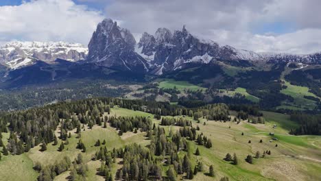 alpe di siusi and sassolungo group in the dolomites, with drone capturing snow-capped peaks and green meadows