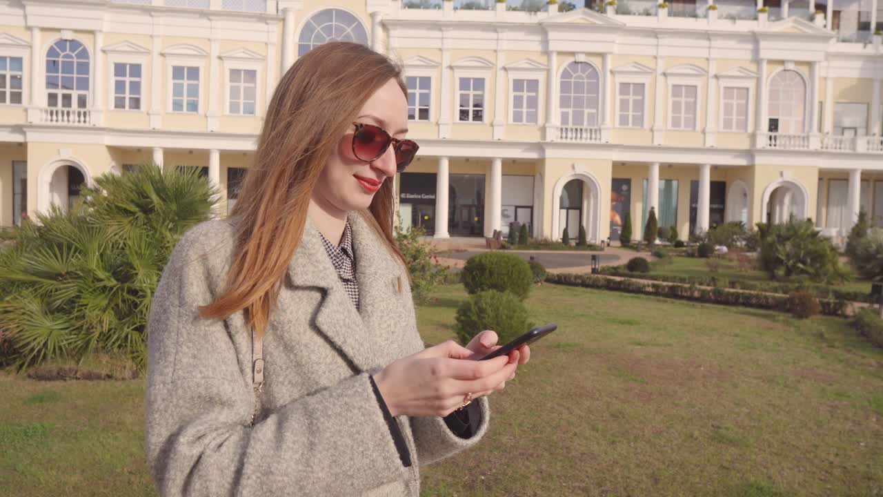 Woman using phone in front of a shopping mall