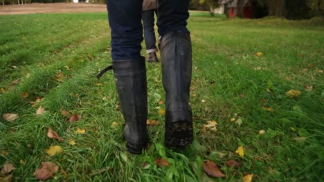 Perfekte-Fokusaufnahme-Von-Den-Beinen-Zweier-Männer,-Die-Im-Herbst-Auf-Gelben-Blättern-Laufen