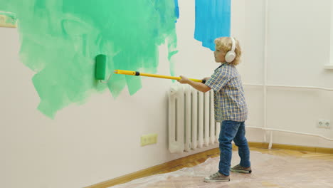 child painting wall with paint roller