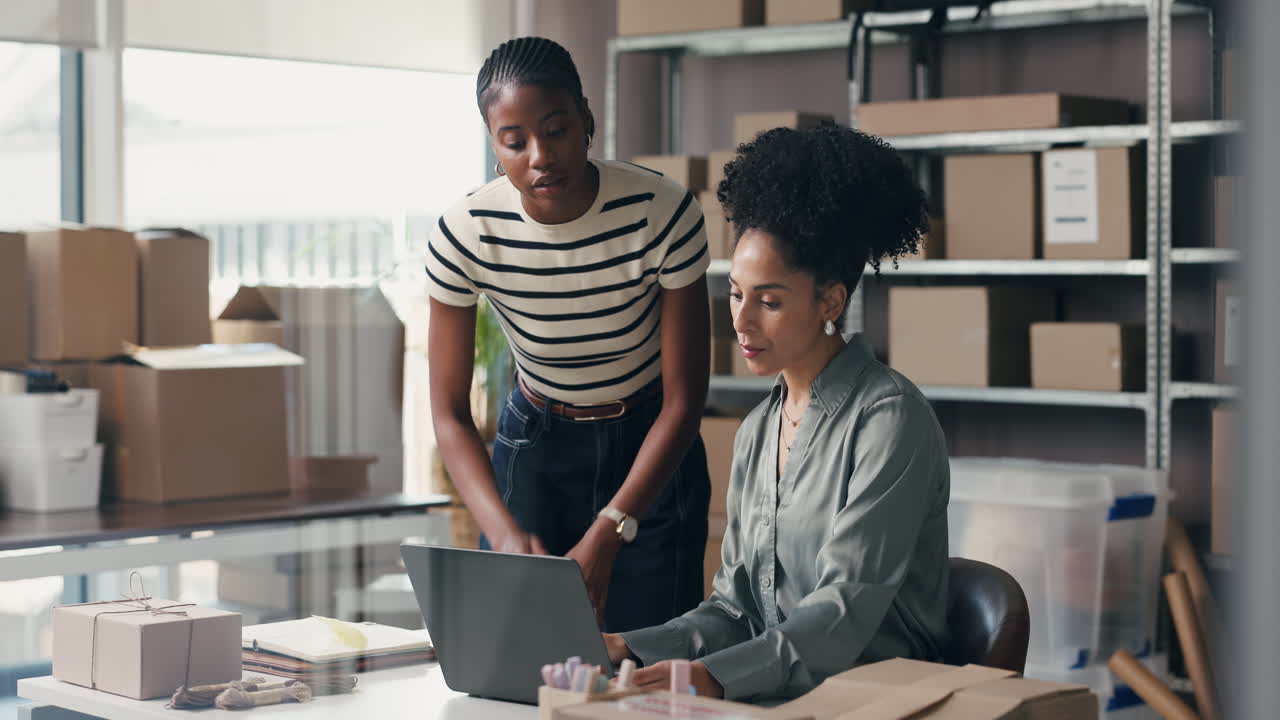 Due donne diverse collaborano al laptop in un ufficio e-commerce