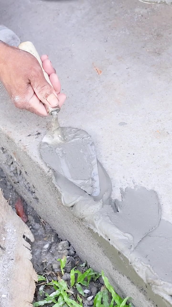 Construction Worker Applying Cement Mortar to Concrete Edge
