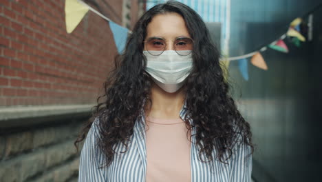 woman wearing a mask in an urban alleyway