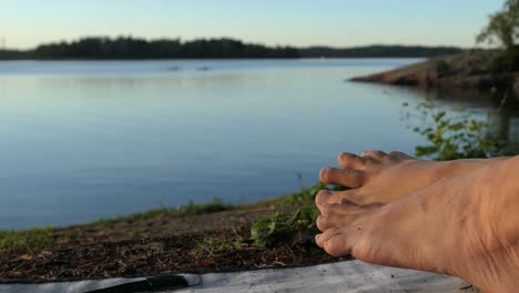 calm sea bare feet close up at summer evening sunset