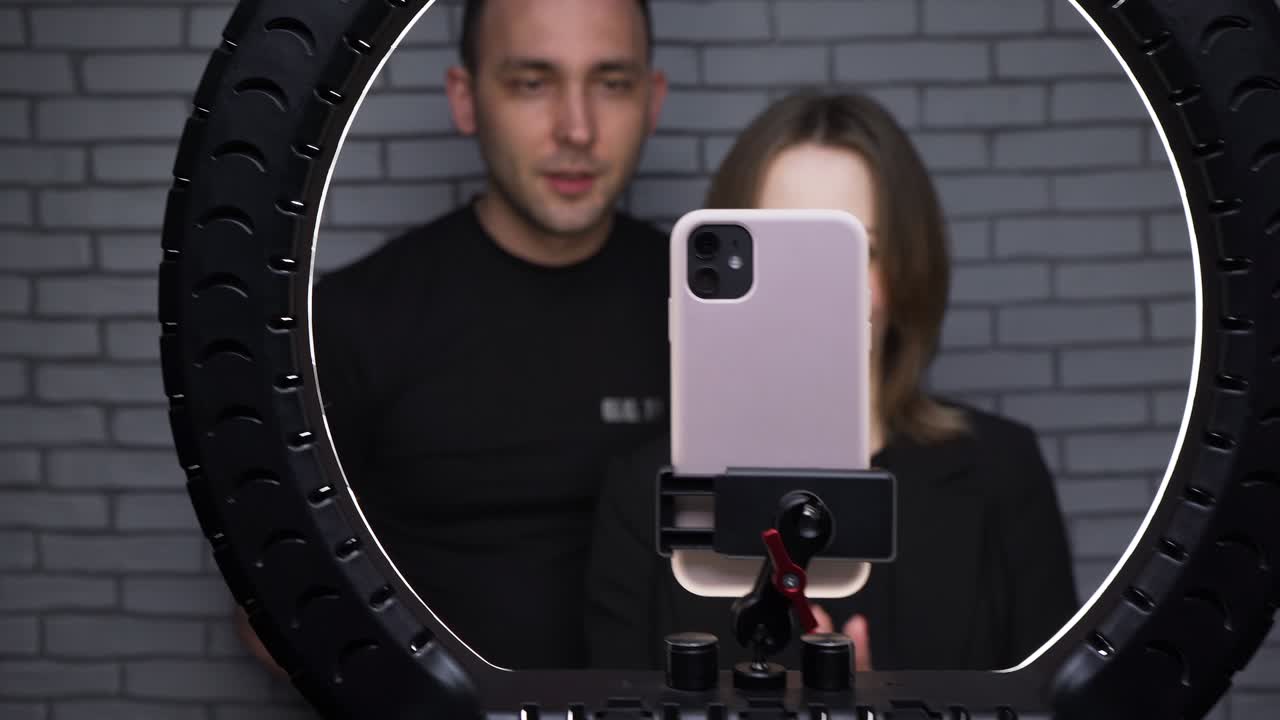 disparo de una pareja hablando con sus seguidores en el fondo de la pared de ladrillo