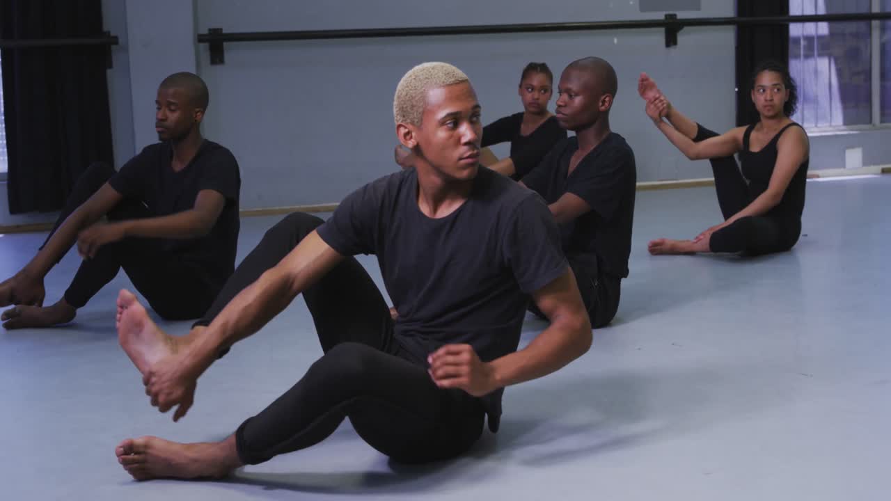 Multi-ethnic group of fit male and female modern dancers practicing a dance routine
