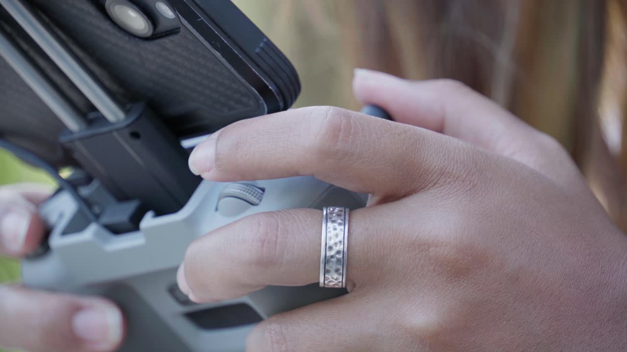 여자 는 외부 에서 리모컨 으로 드론 을 제어 하고 있다